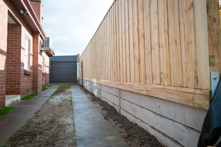 Exposed-post timber paling fence along a driveway