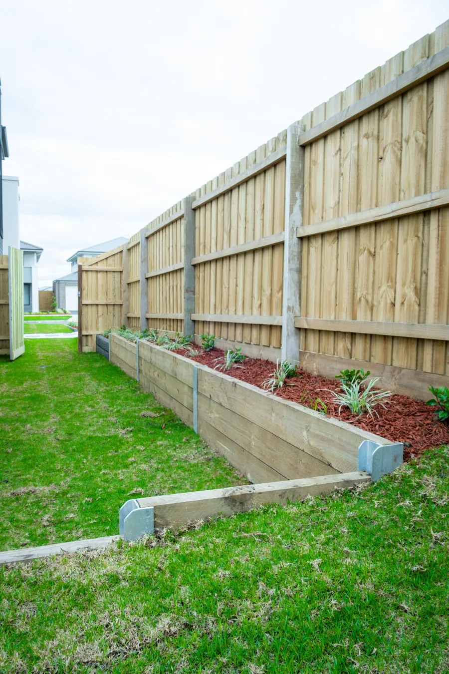 Timber paling on a sleeper garden wall