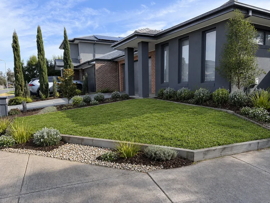 Corner-lot front yard with block retaining edge, lawn and garden beds, finished for handover