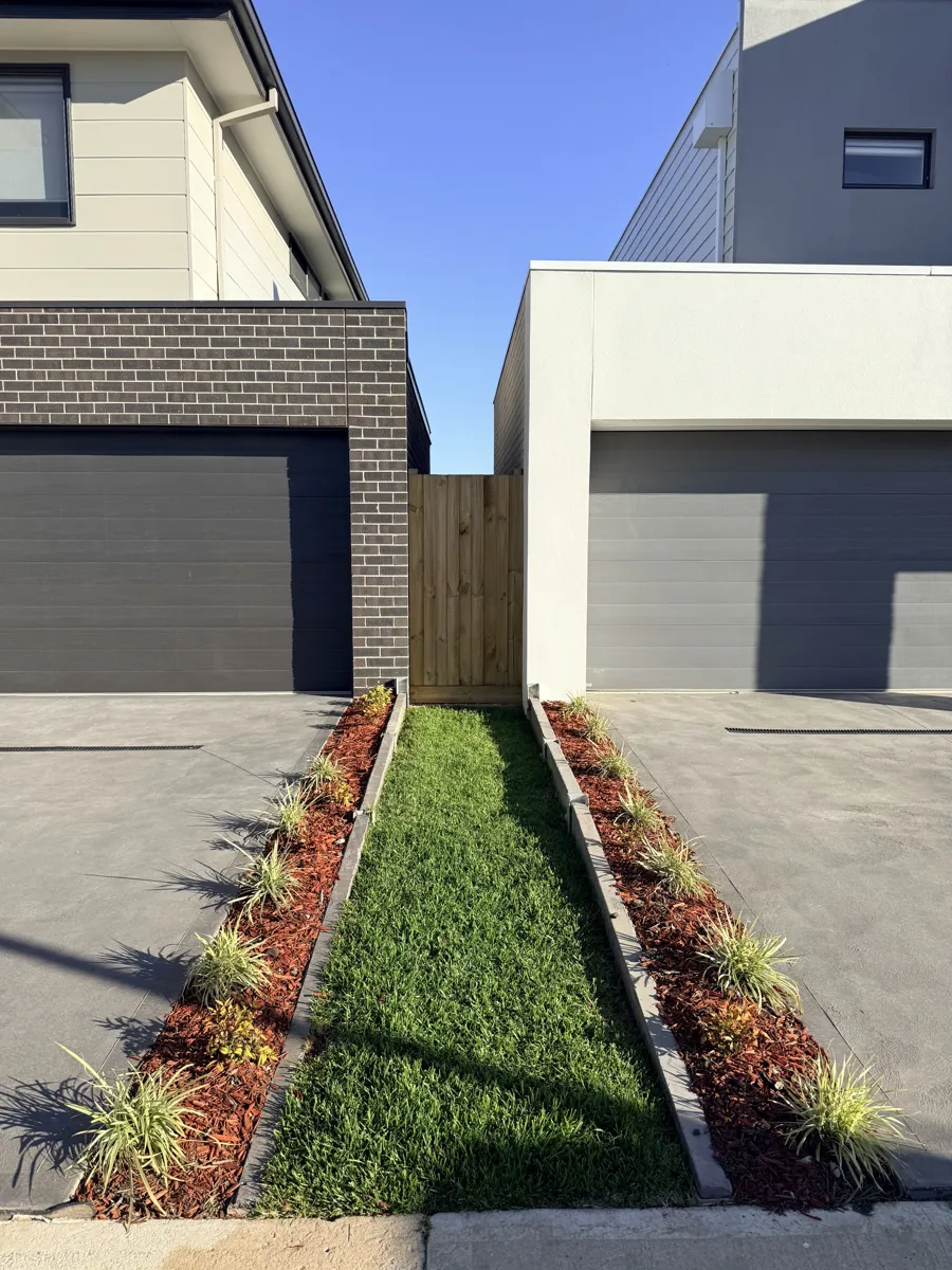 Side garden bed with pavers beside a timber fence