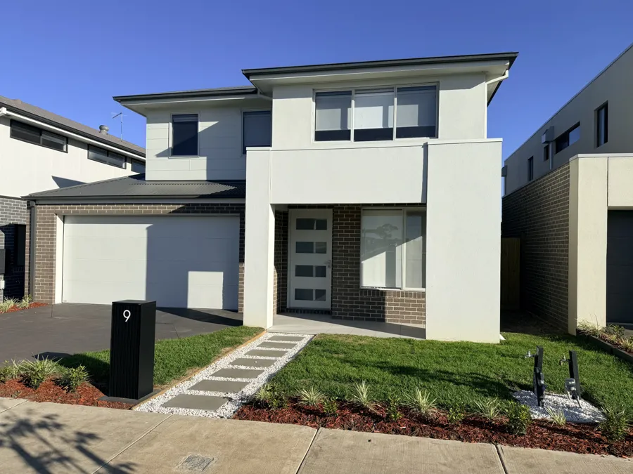 Finished front yard with paved path, lawn and garden beds on a new two-storey home